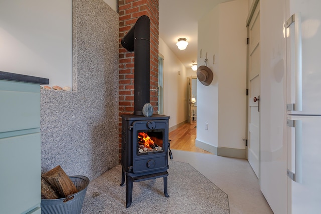 421 Petitmanan Point Rd, Steuben, ME 04680 - detailed view of a wood stove and freestanding refrigerator