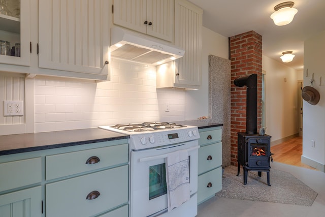 421 Petitmanan Point Rd, Steuben, ME 04680 - kitchen featuring white gas range oven, under cabinet range hood, decorative backsplash, and dark countertops