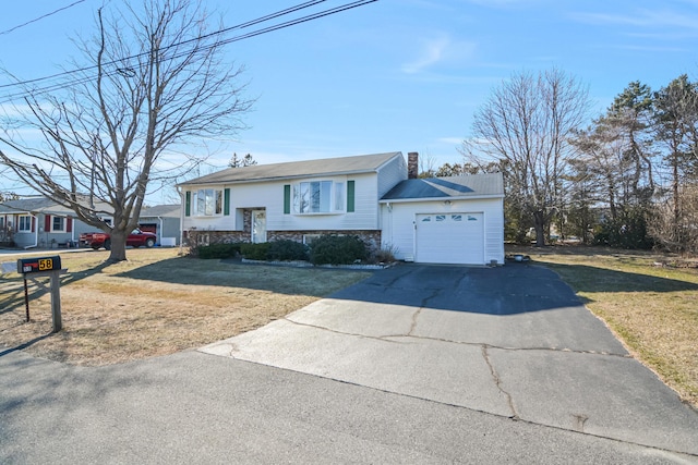 58 Bayview Ter, Wells, ME 04090 - bi-level home featuring an attached garage, stone siding, driveway, a front lawn, and a chimney