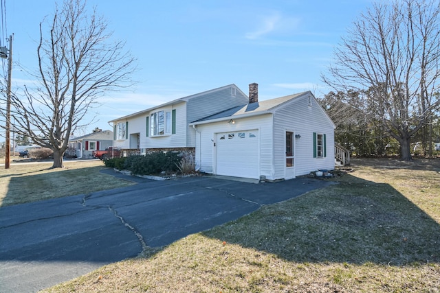 58 Bayview Ter, Wells, ME 04090 - view of front of property featuring driveway, a chimney, a front lawn, and an attached garage