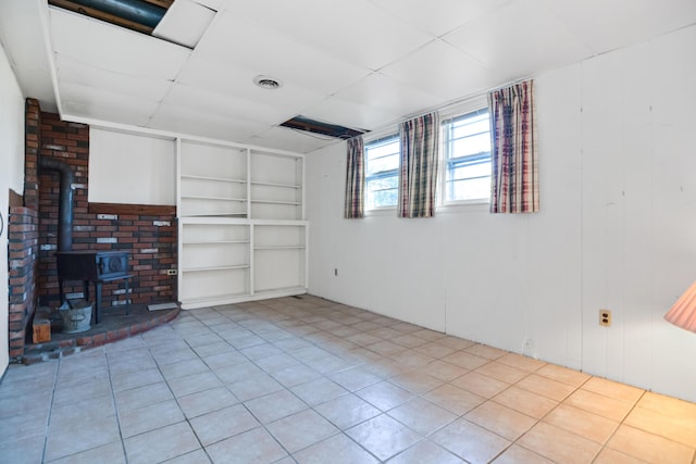 58 Bayview Ter, Wells, ME 04090 - basement with built in features, visible vents, a wood stove, and tile patterned floors