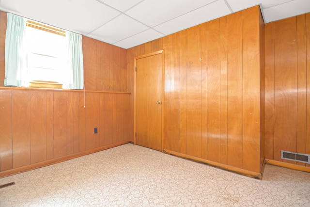 58 Bayview Ter, Wells, ME 04090 - spare room with a paneled ceiling, tile patterned floors, wooden walls, and visible vents
