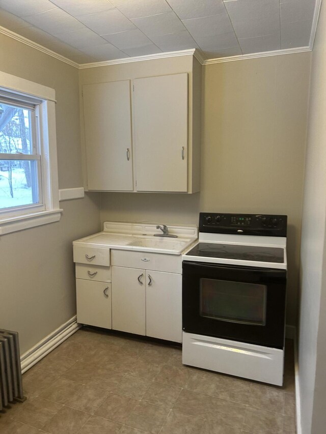 kitchen with light countertops, ornamental molding, radiator heating unit, range with electric cooktop, and a sink