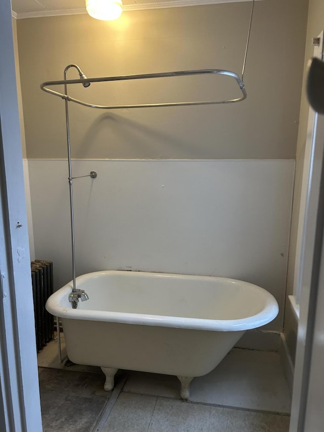 bathroom featuring a soaking tub and radiator