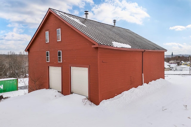 57 Oxford St, Augusta, ME 04330 - view of snowy exterior with a garage, a standing seam roof, and metal roof