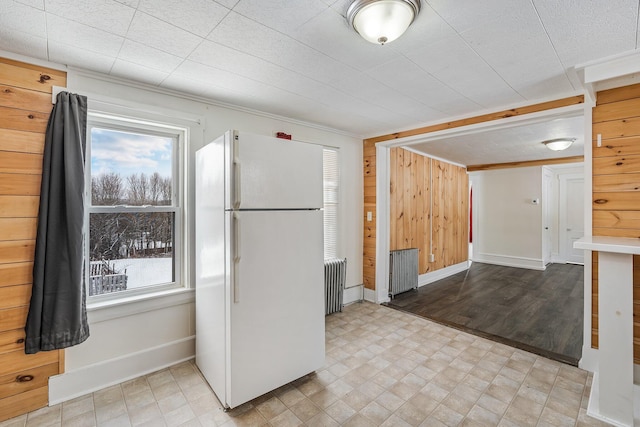 57 Oxford St, Augusta, ME 04330 - kitchen featuring baseboards, freestanding refrigerator, radiator heating unit, and wood walls