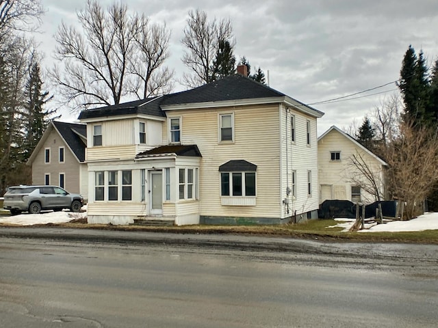 traditional-style home with a chimney and entry steps