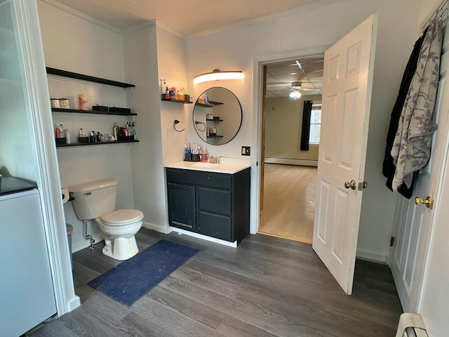 bathroom with crown molding, a baseboard radiator, wood finished floors, toilet, and a baseboard heating unit