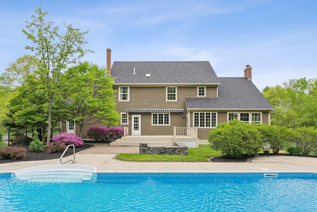 31 Green Trees Dr, Gorham, ME 04038 - back of house with a chimney, a wooden deck, and an outdoor pool