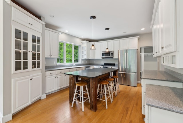 31 Green Trees Dr, Gorham, ME 04038 - kitchen with stainless steel appliances, a breakfast bar, white cabinets, open shelves, and light wood-type flooring
