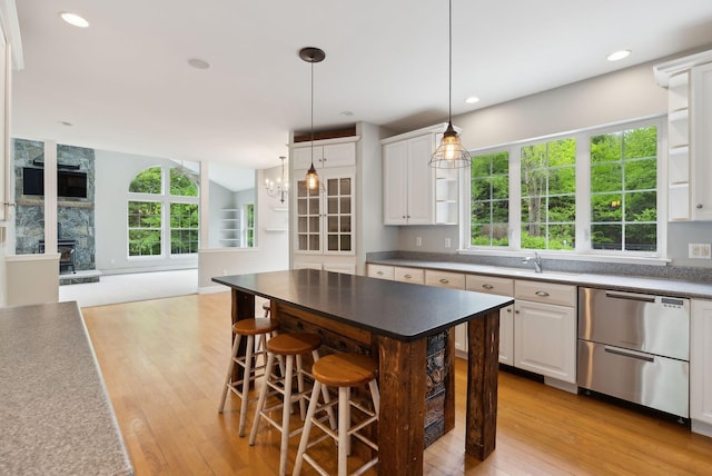 31 Green Trees Dr, Gorham, ME 04038 - kitchen with stainless steel dishwasher, a sink, open shelves, light wood finished floors, and white cabinets