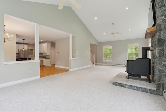 31 Green Trees Dr, Gorham, ME 04038 - unfurnished living room with ceiling fan, light carpet, a wood stove, a baseboard heating unit, and high vaulted ceiling