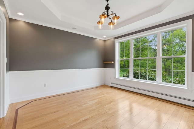 31 Green Trees Dr, Gorham, ME 04038 - spare room with a baseboard heating unit, a chandelier, a raised ceiling, light wood-style floors, and crown molding