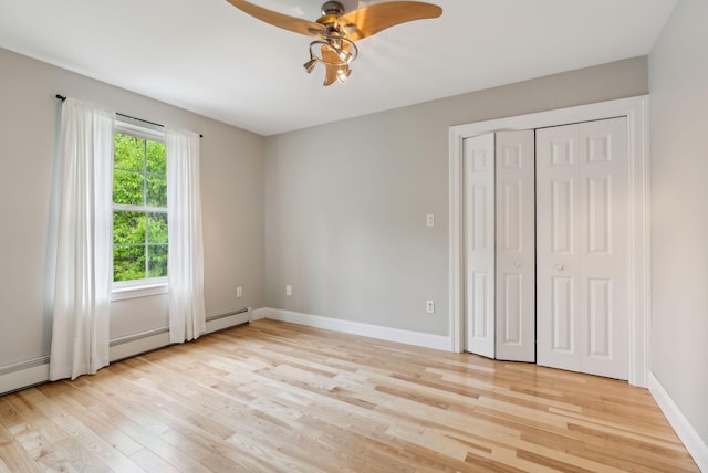 31 Green Trees Dr, Gorham, ME 04038 - unfurnished bedroom featuring light wood finished floors, baseboards, ceiling fan, a closet, and baseboard heating
