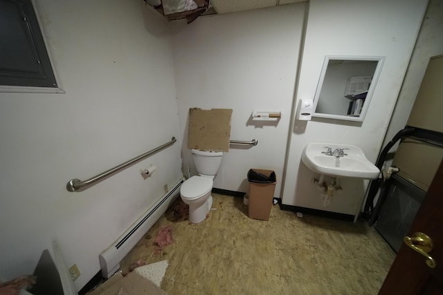 48 Customs Loop, Houlton, ME 04730 - half bath with a sink, toilet, electric panel, and a baseboard radiator