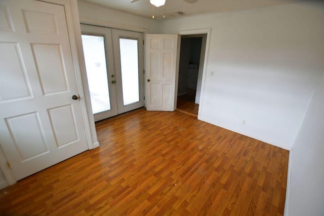 interior space featuring baseboards, french doors, wood finished floors, and a ceiling fan
