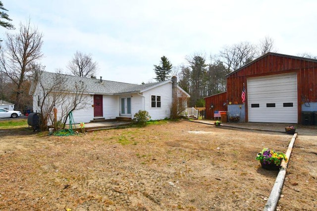 single story home with an outdoor structure, driveway, a detached garage, and french doors