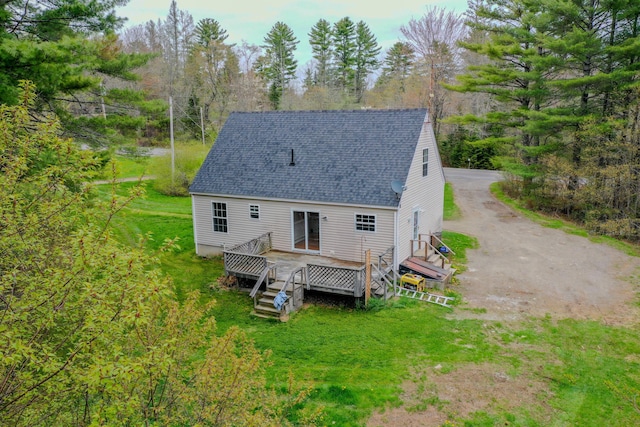 452 Moosehead Trl, Waldo, ME 04915 - rear view of house featuring roof with shingles, a deck, view of scattered trees, and a yard