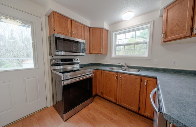 452 Moosehead Trl, Waldo, ME 04915 - kitchen with appliances with stainless steel finishes, a sink, light wood-style floors, plenty of natural light, and a textured ceiling