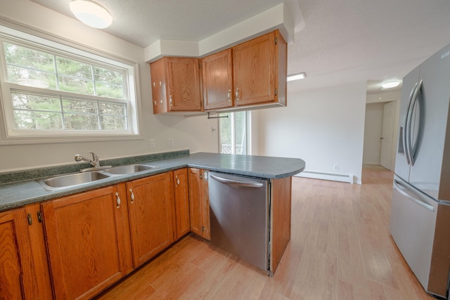 452 Moosehead Trl, Waldo, ME 04915 - kitchen featuring appliances with stainless steel finishes, baseboard heating, a sink, brown cabinetry, and light wood-type flooring