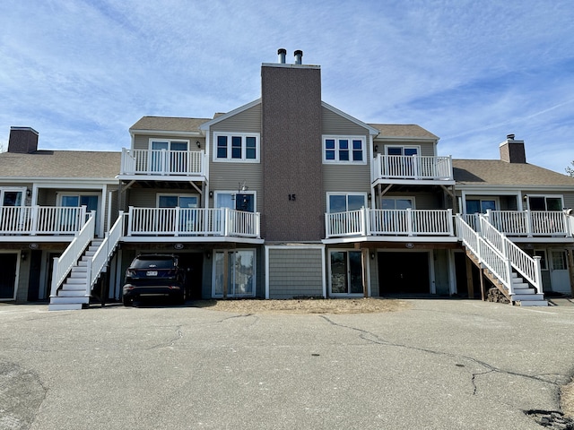 view of building exterior featuring stairs, a garage, and aphalt driveway