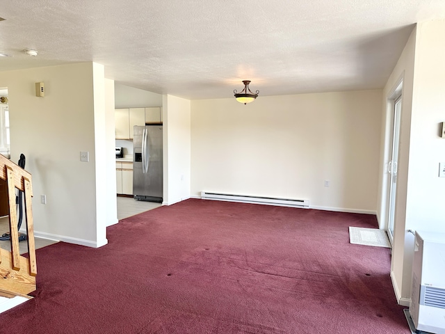unfurnished living room with baseboards, carpet floors, a textured ceiling, and a baseboard heating unit