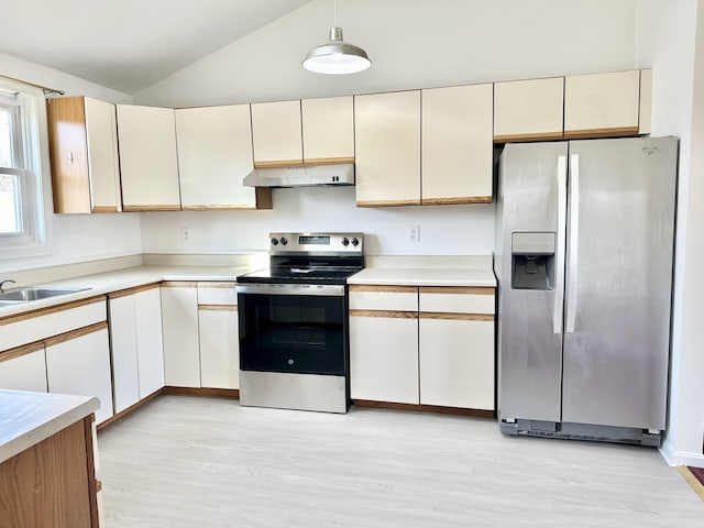 kitchen with light countertops, vaulted ceiling, under cabinet range hood, a sink, and appliances with stainless steel finishes