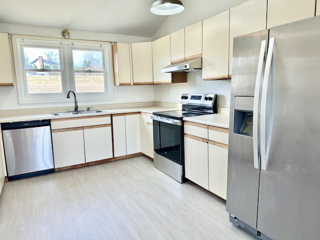 kitchen with light countertops, appliances with stainless steel finishes, under cabinet range hood, a sink, and light wood-type flooring