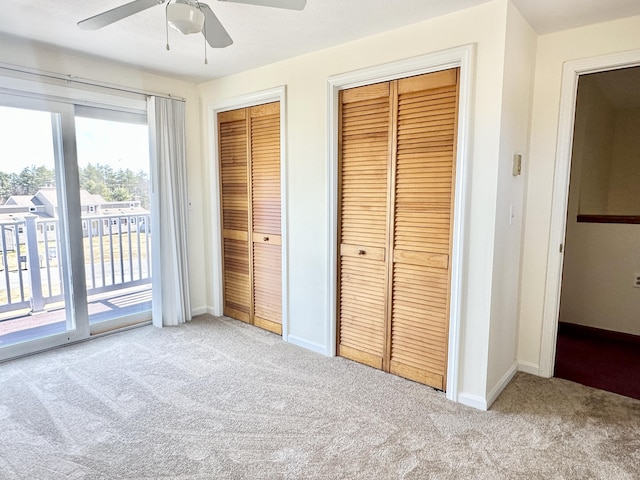 unfurnished bedroom featuring carpet flooring, multiple closets, baseboards, access to outside, and a ceiling fan