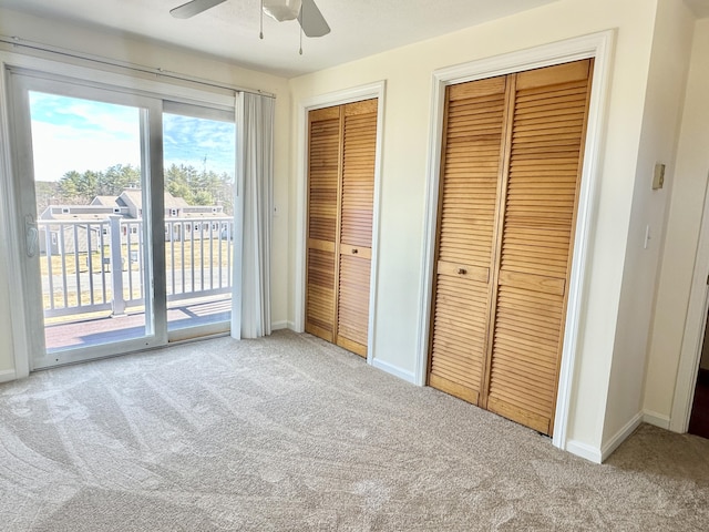 unfurnished bedroom with access to exterior, carpet flooring, baseboards, two closets, and ceiling fan