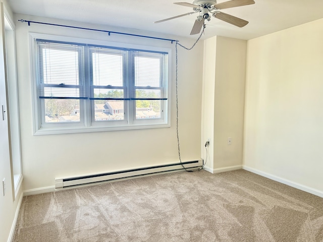 spare room with baseboards, ceiling fan, carpet, and a baseboard radiator