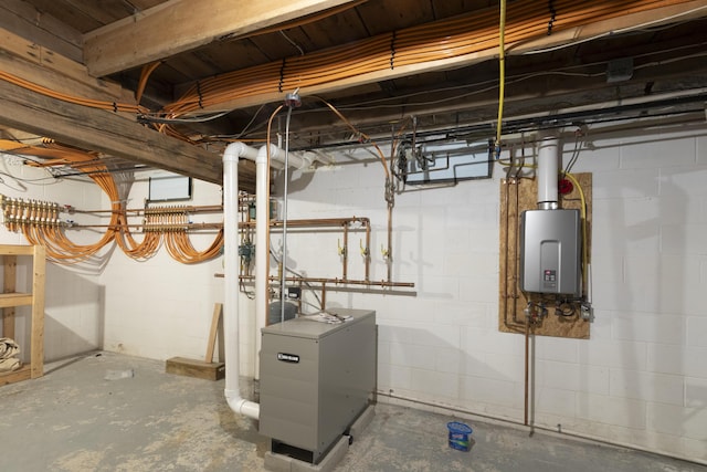 utility room with tankless water heater and a heating unit