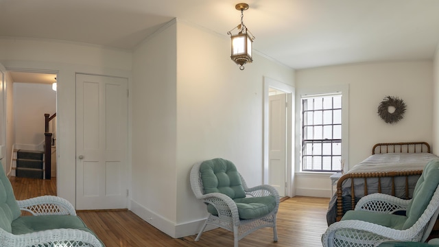 bedroom featuring crown molding, baseboards, and wood finished floors