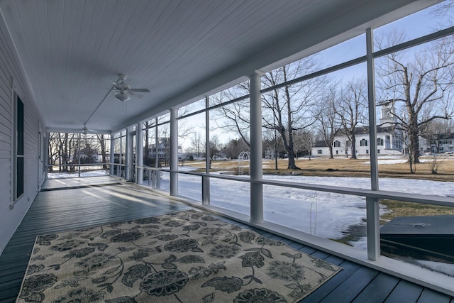 unfurnished sunroom featuring ceiling fan and a healthy amount of sunlight