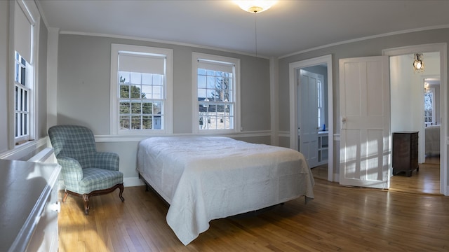 bedroom featuring ornamental molding and hardwood / wood-style flooring