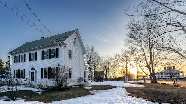 snow covered property featuring metal roof
