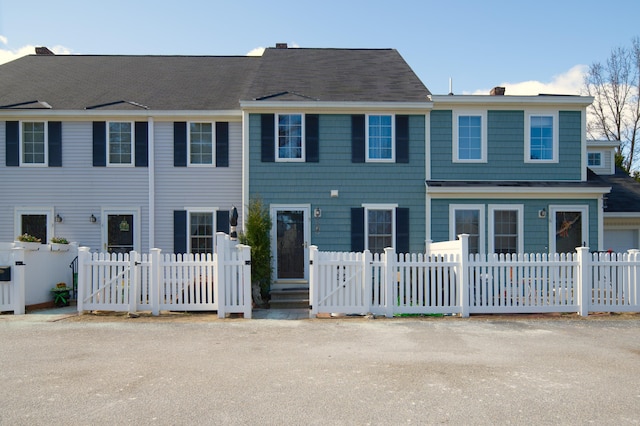 multi unit property with a fenced front yard and a chimney