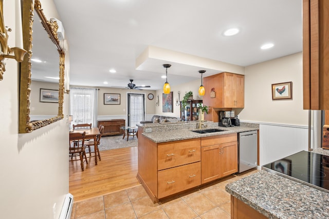 kitchen with a peninsula, a sink, a baseboard heating unit, stainless steel dishwasher, and light tile patterned floors