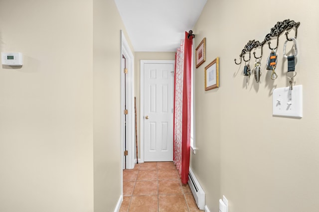 corridor with baseboards, baseboard heating, and light tile patterned floors