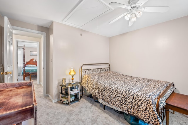 carpeted bedroom featuring attic access, baseboards, and ceiling fan