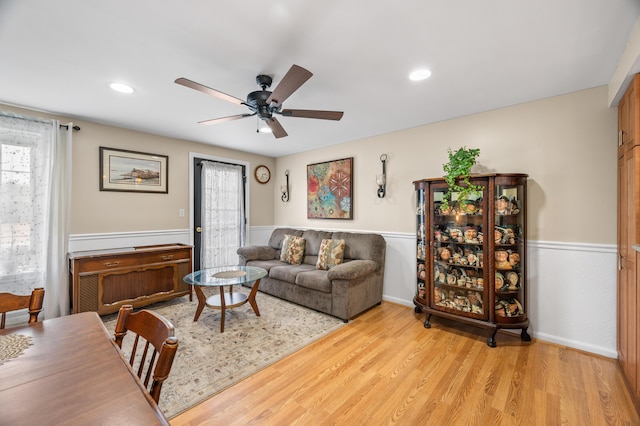 living area with baseboards, ceiling fan, light wood-style flooring, and recessed lighting