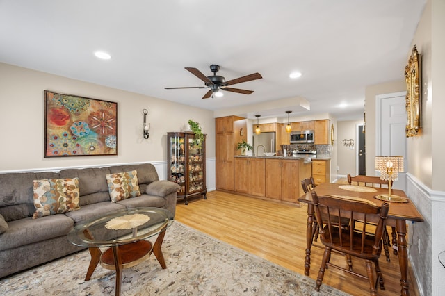 living area with light wood-type flooring, recessed lighting, and a ceiling fan