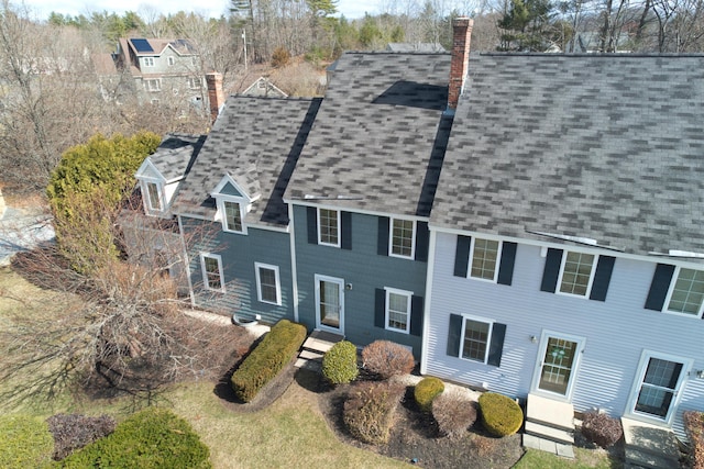 exterior space with a chimney and a shingled roof