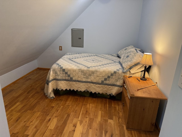 148 Pendleton Point Rd, Islesboro, ME 04848 - bedroom with wood finished floors, electric panel, vaulted ceiling, and baseboards