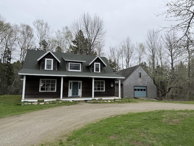 148 Pendleton Point Rd, Islesboro, ME 04848 - view of front facade featuring a detached garage, dirt driveway, covered porch, a front lawn, and an outdoor structure
