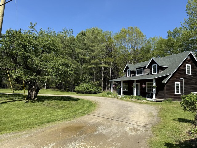 148 Pendleton Point Rd, Islesboro, ME 04848 - view of front of house with covered porch, driveway, a front yard, and a shingled roof