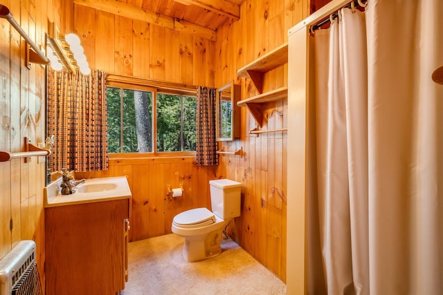 bathroom with wooden walls, toilet, beamed ceiling, wood ceiling, and vanity