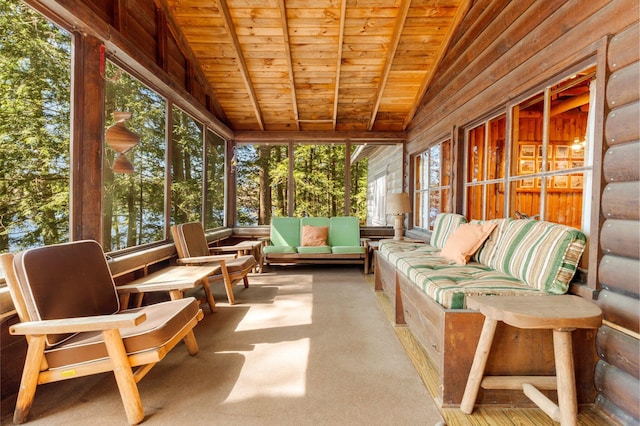 sunroom / solarium with plenty of natural light, lofted ceiling, and an outdoor hangout area