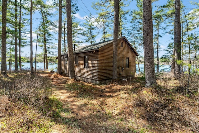 view of side of home featuring log veneer siding and a water view