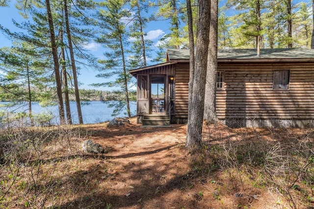 view of side of property featuring a water view and faux log siding